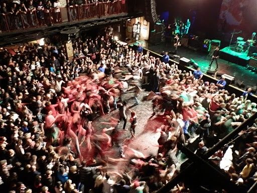 Großer Moshpit vor einer Rockbühne mit dicht gedrängtem Publikum