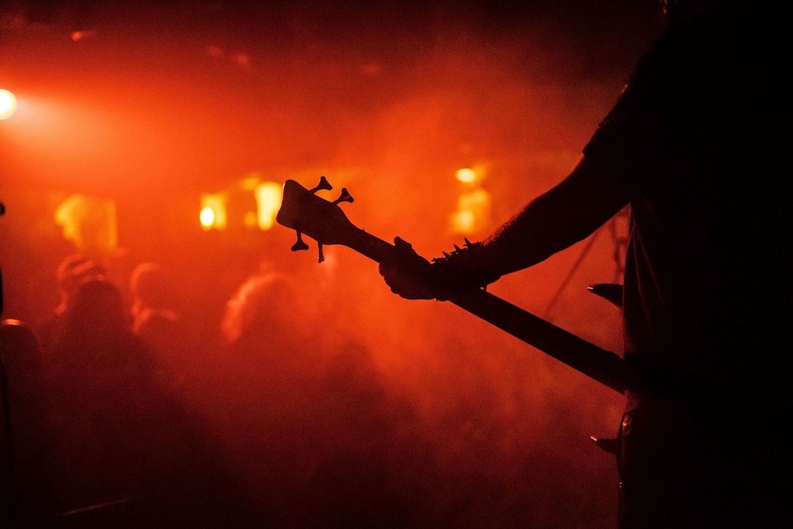 Silhouette eines Bassisten im roten Licht bei einem Heavy-Metal-Konzert